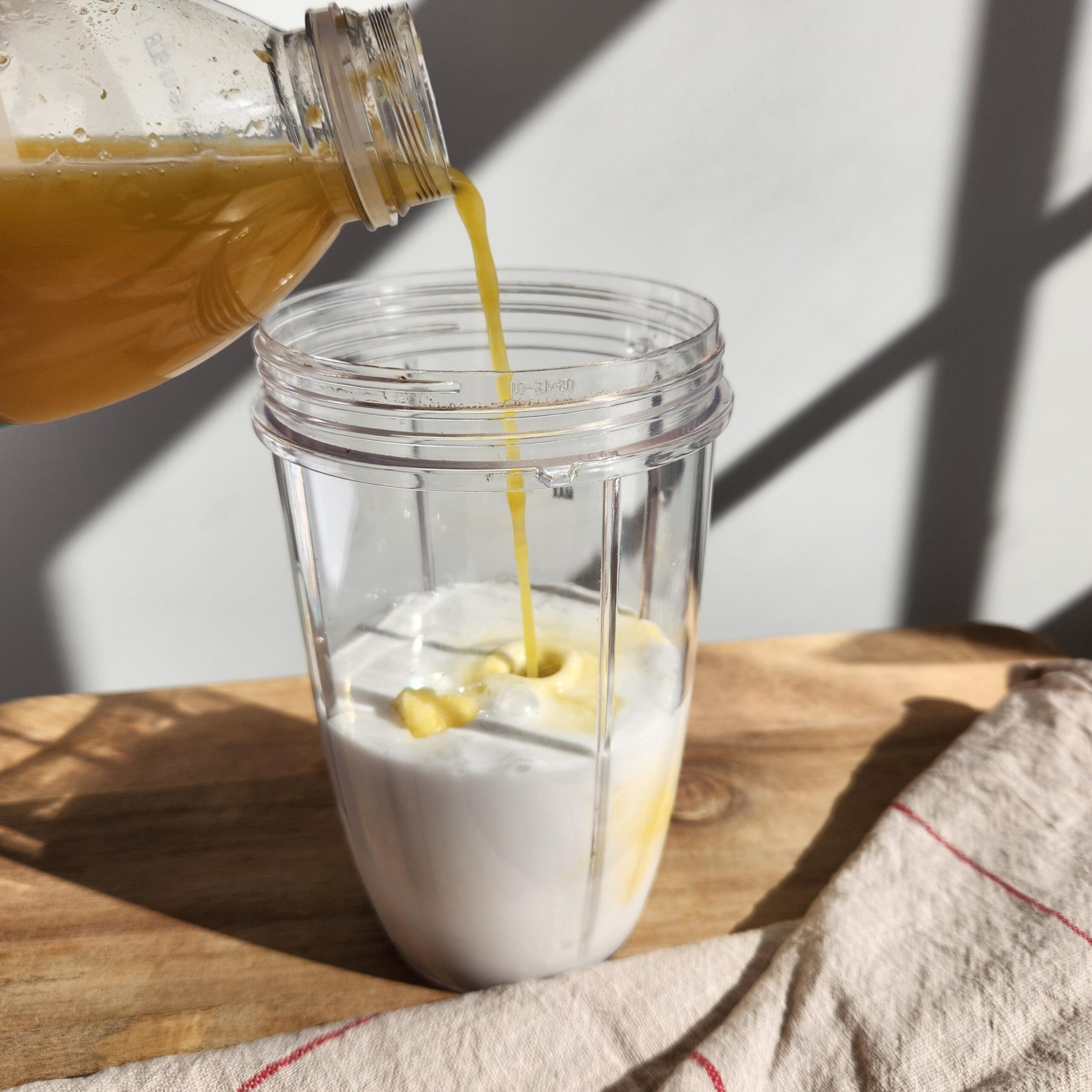pour final ingredient, the orange juice, into the smoothie blender cup