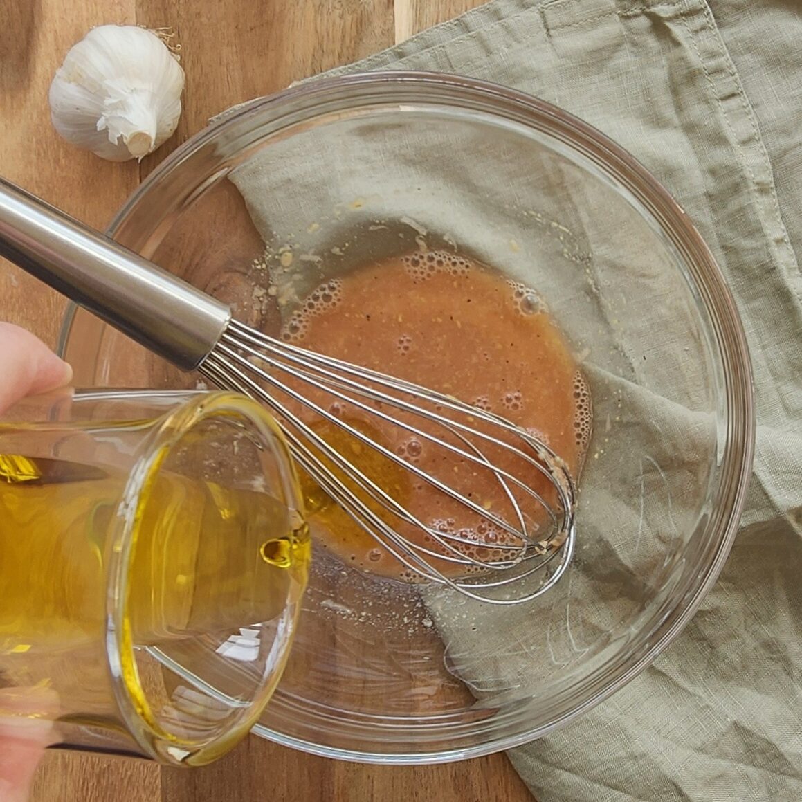 whisking olive oil into the bowl
